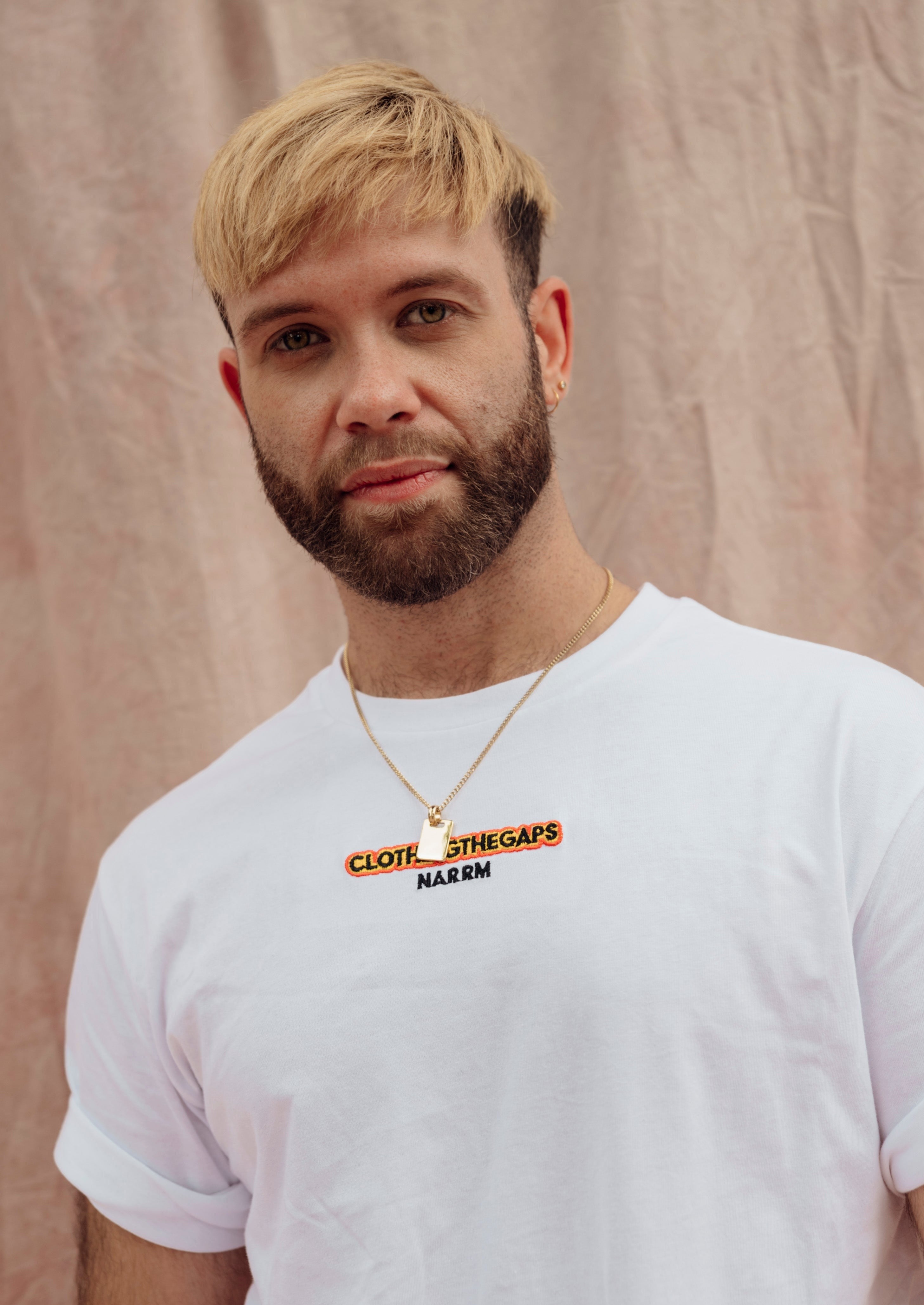 Clothing The Gaps. Spirit Tee. White T-shirt. With embroidered 'Clothing The Gaps' on front chest with minimalist font in black text with a yellow and red outline and 'Narrm' in black embroidered underneath, acknowledging the land on which Clothing The Gaps operates it's social enterprise.